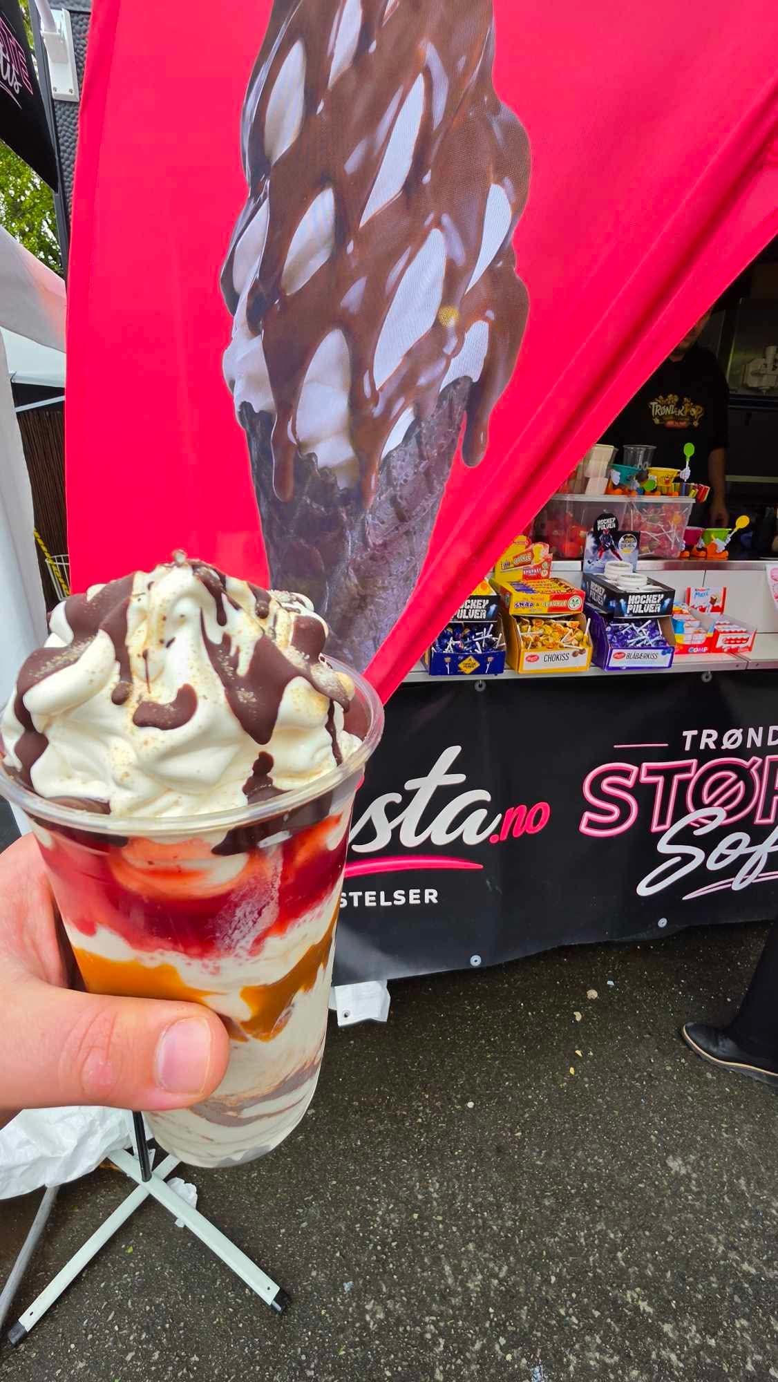 Softisbeger med jordbær, karamell og sjokoladesaus foran standen